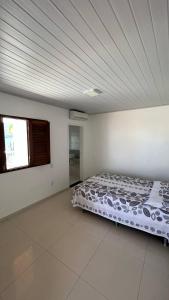 a bedroom with a bed in a white room at Casa abençoada in Barra de São Miguel
