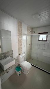 a bathroom with a toilet and a sink and a shower at Casa abençoada in Barra de São Miguel