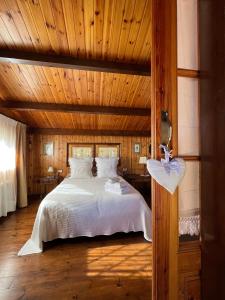 a bedroom with a bed with a wooden ceiling at Xalet de Cal Fera in La Coma i la Pedra