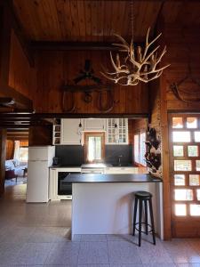 a kitchen with a counter and a chandelier at Xalet de Cal Fera in La Coma i la Pedra