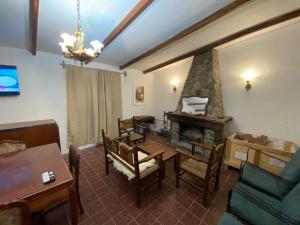 a living room with a table and a fireplace at CASA DE CAMPO POTRERILLOS in Potrerillos