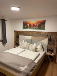 a bedroom with a large bed with a painting on the wall at Haus Almweg in Kirchberg in Tirol