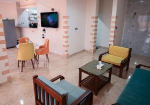 a living room with chairs and a tv on a wall at Kana Kato in Aswan