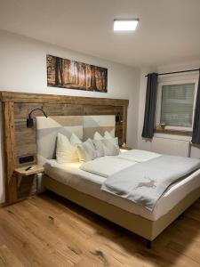 a bedroom with a large bed with a wooden headboard at Haus Almweg in Kirchberg in Tirol