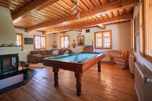 a living room with a pool table and a fireplace at Chaty Rozprávkovo in Vysoke Tatry - Tatranska Lomnica.