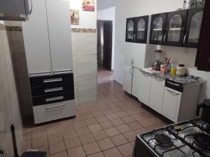 una cocina con armarios blancos y fogones. en Casa encantadora em João pessoa, en João Pessoa