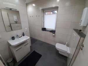 a white bathroom with a sink and a toilet at Kelbergerly Hills in Kelberg