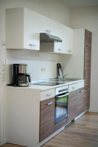 a kitchen with white cabinets and a stove top oven at Kelbergerly Hills in Kelberg