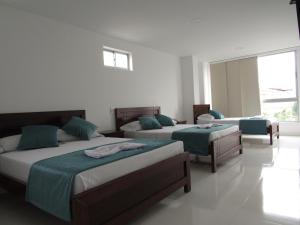 1 dormitorio con 2 camas y ventana en Hotel Plaza Berlín, en Medellín