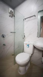 ein Bad mit einem WC, einem Waschbecken und einer Dusche in der Unterkunft SANDS Hotel Nasugbu in Nasugbu