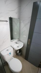 納蘇格布的住宿－SANDS Hotel Nasugbu，浴室配有白色卫生间和盥洗盆。