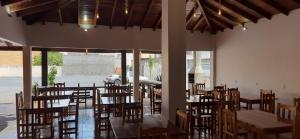 a dining room with tables and chairs and windows at HOTEL TROPICAL in Jardim +51 photos