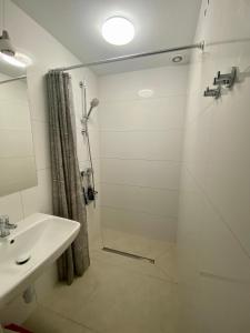 La salle de bains est pourvue d'une douche et d'un lavabo. dans l'établissement Hostel WAWA More, à Varsovie