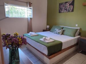 a bedroom with a bed with a vase of flowers at Olive Grove Cottage Skalani in Knossós