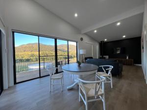 a living room with a table and chairs and a large window at Vineyard stay at Mudgee in Apple Tree Flat