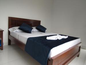 1 dormitorio con 1 cama grande con almohadas azules en Hotel Plaza Berlín, en Medellín