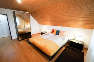 Centra Hotel Zurich في باسردورف: غرفة نوم بسرير كبير بسقف خشبي