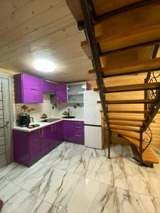 a purple kitchen with purple cabinets and a staircase at Vienna House in Yaremche