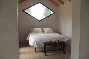 1 dormitorio con 1 cama con ventana y mesa con velas en Cabaña El Rey y las golondrinas en Lago Puelo