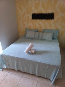 a bed with a towel on top of it at Pousada Aloha Guarapari in Guarapari