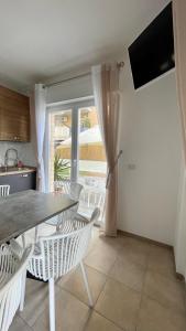 a dining room with a table and chairs and a window at AMERICAN GARDEN HOUSE in Nettuno