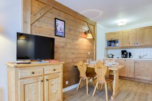 a kitchen and dining room with a television and a table at Les Alpages du Corbier A102 in Villarembert