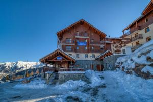 a large building with snow in front of it at Les Alpages du Corbier A102 in Villarembert