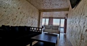 a room with a couch and a table and a window at Lazy Lounge Apartments & Rooms in Mangalia
