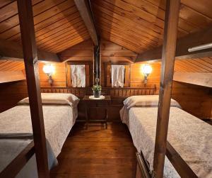 two beds in a room with wooden ceilings at Xalet de Cal Fera in La Coma i la Pedra