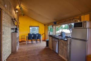 cocina y zona de comedor de una cabaña en JOINS! Glamping Aquitaine, en Saint-Aigne