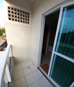 einen Blick vom Balkon eines Hauses mit Glastür in der Unterkunft Pousada Aloha Guarapari in Guarapari