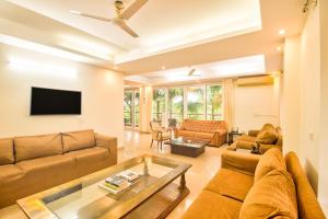 a living room with a couch and a tv at Luxury 3BHK Villa with Private Swimming Pool near Candolim in Marmagao