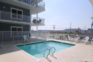 a swimming pool with chairs and a building at OC Condo 4100 #103 in Ocean City
