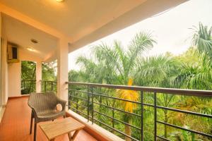 Marmagao的住宿－Luxury 3BHK Villa with Private Swimming Pool near Candolim，阳台配有椅子,享有丛林美景