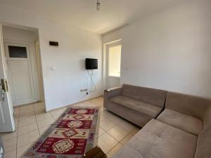 ein Wohnzimmer mit einem Sofa und einem TV in der Unterkunft MAYA in Muğla