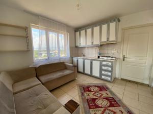 ein Wohnzimmer mit einem Sofa und einer Küche in der Unterkunft MAYA in Muğla