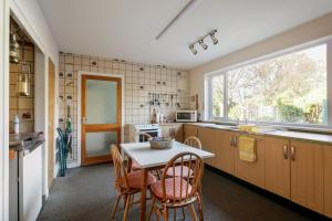 a kitchen with a table and chairs and a window at Bungalow in Spey Bay, Moray (Disabled Accessible) in Kingston