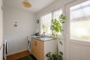 a kitchen with a sink and a washing machine at Bungalow in Spey Bay, Moray (Disabled Accessible) in Kingston