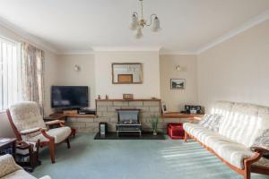 a living room with a couch and a fireplace at Bungalow in Spey Bay, Moray (Disabled Accessible) in Kingston