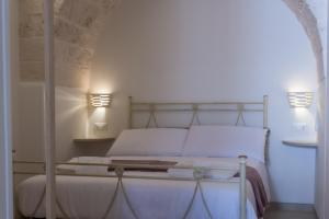 una camera con letto bianco e arco di Suite Dantè - Typical Apulian Rooms a Cisternino