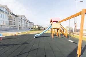 a playground with a slide on a city street at Apartagal-Océano V Barreiros in Barreiros