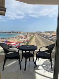 a table and chairs on a balcony with a view of the beach at Blue Whale Hurghada Beach Front Apartments City Centre in Hurghada