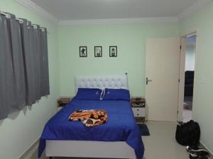 ein Schlafzimmer mit einem Bett mit einer blauen Decke darauf in der Unterkunft Casa e área Gourmet. Cardoso Moreira-RJ in Cardoso Moreira