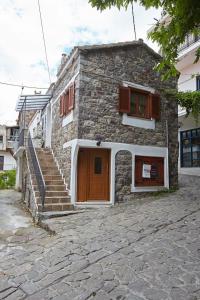 ein Steinhaus mit einer Treppe neben einem Gebäude in der Unterkunft Kadmilos suites Samothraki in Samothráki