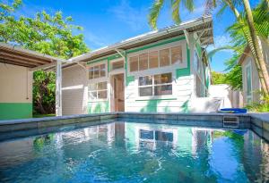 a house with a swimming pool in front of a house at La Garçonniere in Saint-Pierre