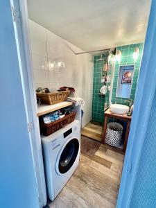 uma máquina de lavar roupa na casa de banho com um lavatório em IVY - Classical & modern apartment in lovely neighbourhood near beach em Haia