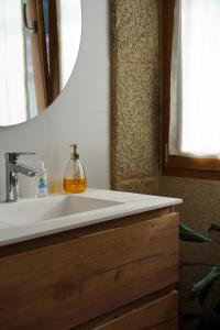 Casa de Chica Ecoturismo في Lousame: حمام مع حوض أبيض ومرآة