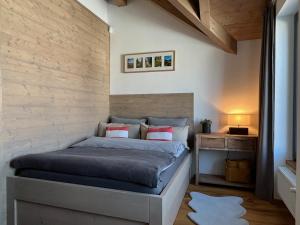 1 dormitorio con 1 cama y pared de madera en VILLA BOHEMIA - Boží Dar en Boží Dar