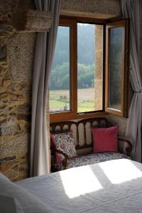 Casa de Chica Ecoturismo في Lousame: غرفة نوم بسرير ونافذة بها كنب