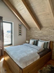 1 dormitorio con 1 cama grande y pared de ladrillo en VILLA BOHEMIA - Boží Dar en Boží Dar